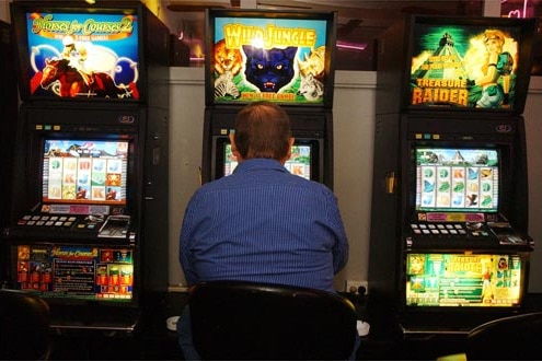 Man playing poker machine.