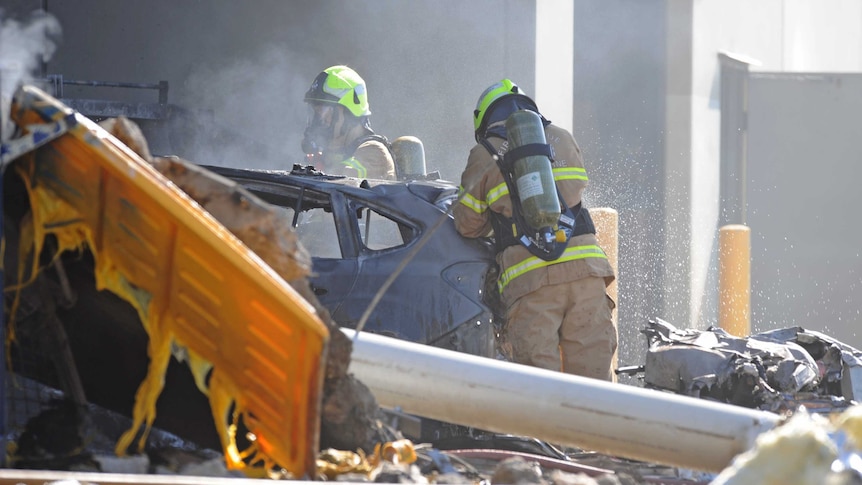 Emergency services personnel are seen at the scene of a plane crash in Essendon, Victoria, Australia.