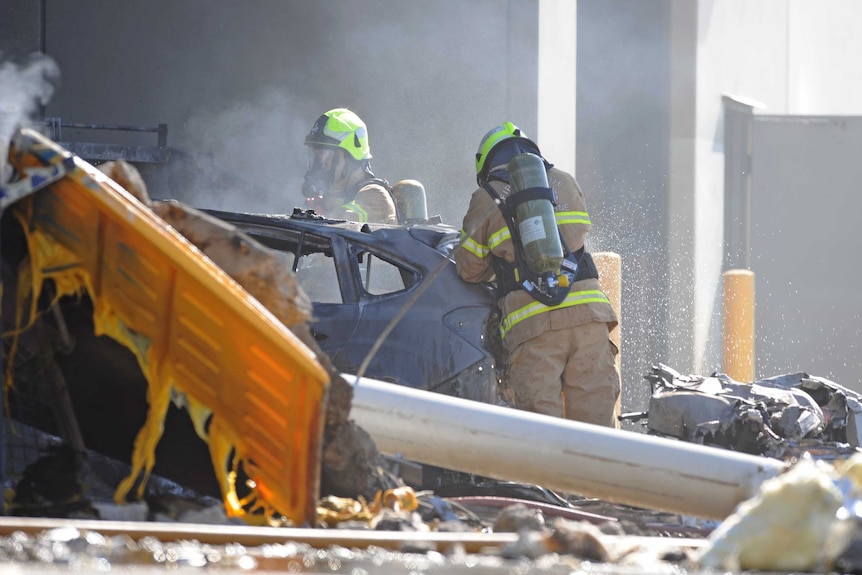 Emergency services personnel are seen at the scene of a plane crash in Essendon, Victoria, Australia.