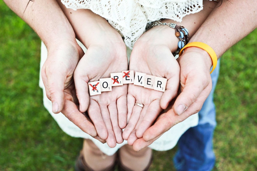 Scrabble letters spelling forever, but some are crossed out to spell over to depict the pressure that debt puts on relationships