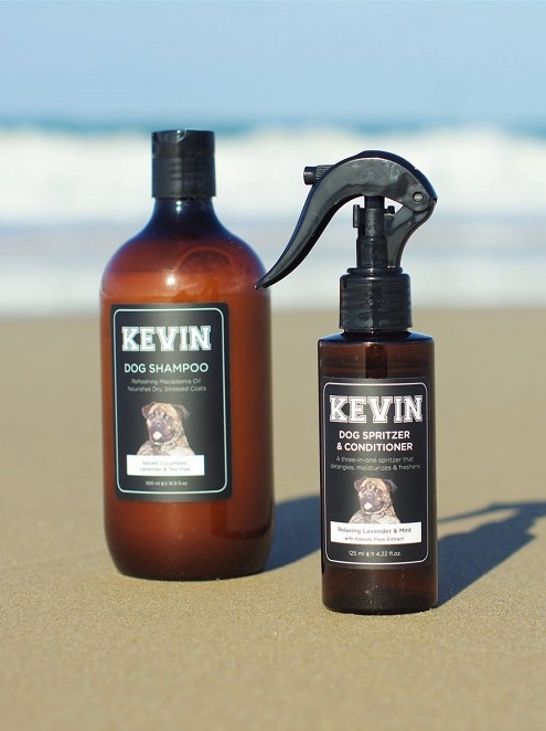 A photo of two bottles with the dogs face on the label sitting on the beach