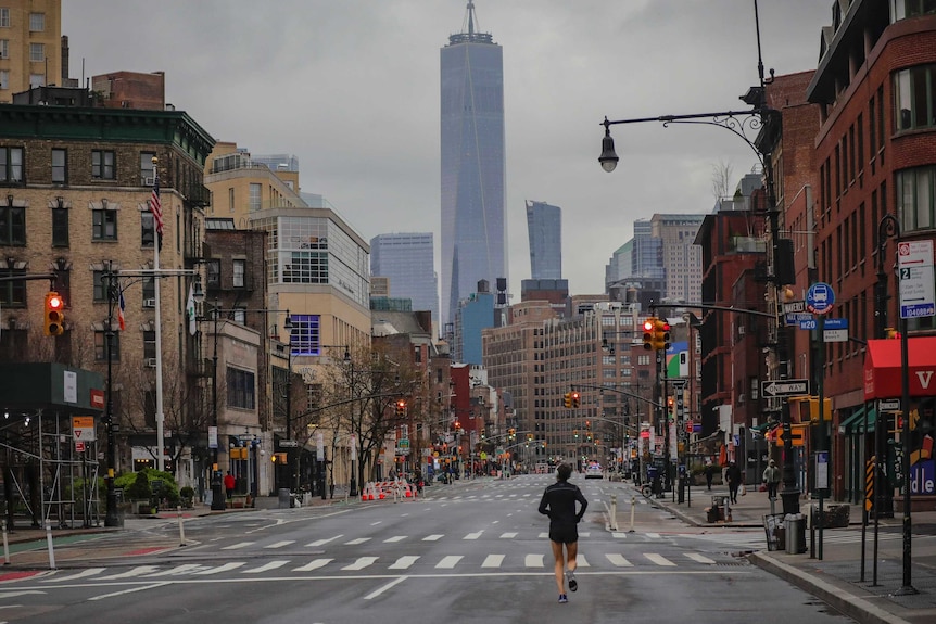 A lone jogger run on a partially empty 7th Avenue in New York City.