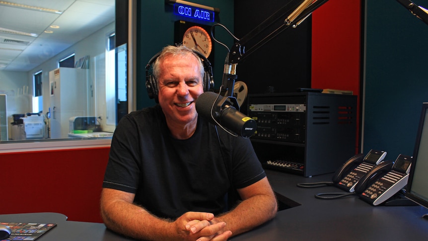 Craig Widdowson sitting in the studio behind a microphone and radio panel