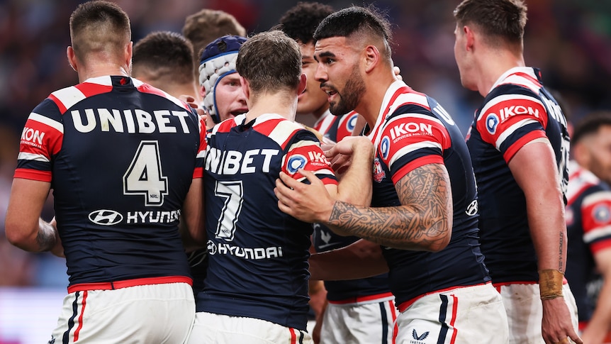 Teammates congratulate a rugby league player after he scored a try