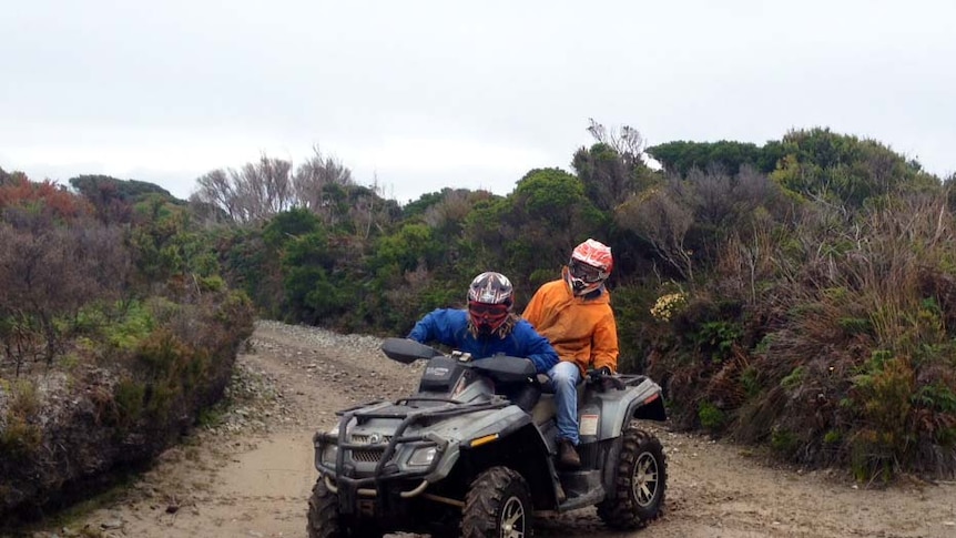 Two people ride a quad bike on a track on Tasmania's west coast.