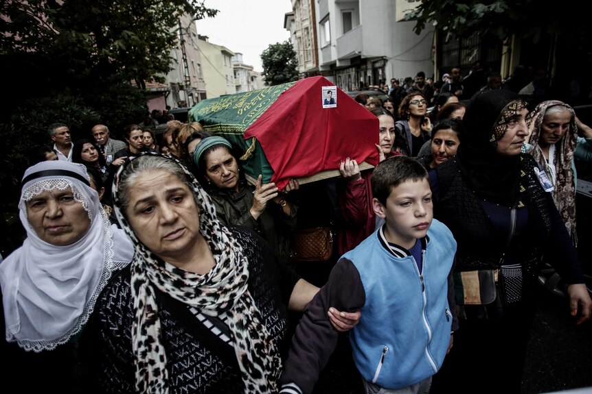Mourners carrying a coffin through the streets