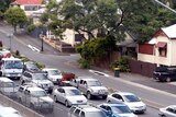 Peak hour traffic passes close by residential houses on Hale Street
