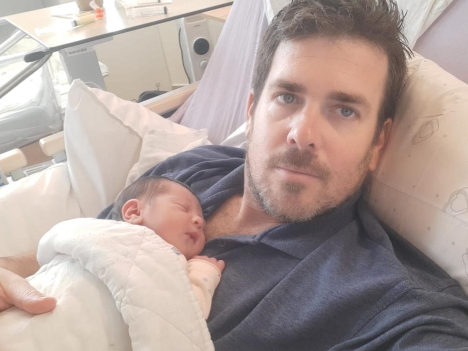 A man holding a baby in a hospital bed