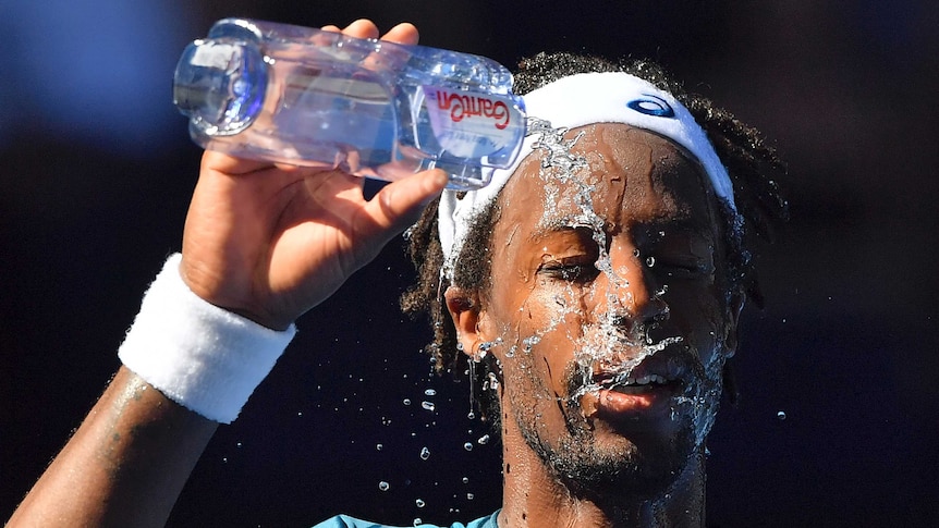 Gael Monfils splashes water on his face.