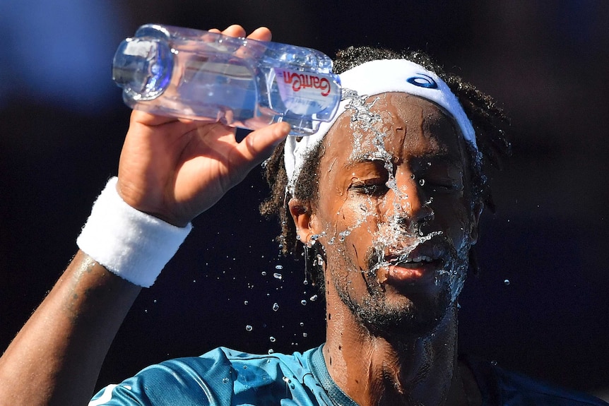 Gael Monfils splashes water on his face.