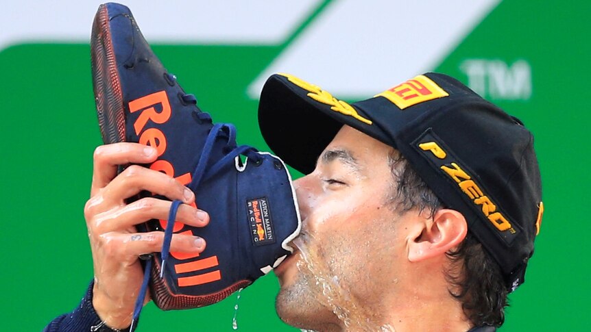 Red Bull's Daniel Ricciardo drinks from a shoe.