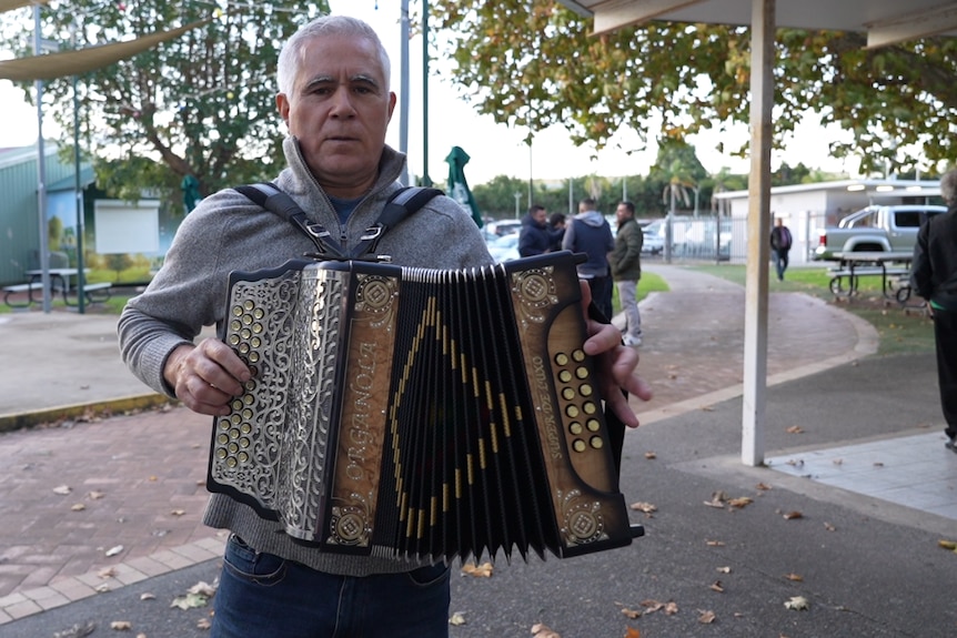 An older man plays an accordion at Sydney's Portugal Community Club.