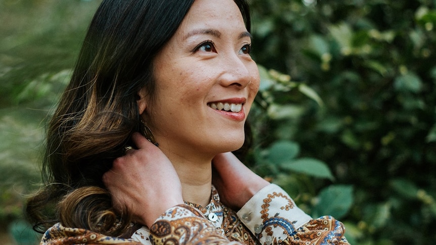 Singer-songwriter Kim Yang stares into the distance with her hands on the back of her neck