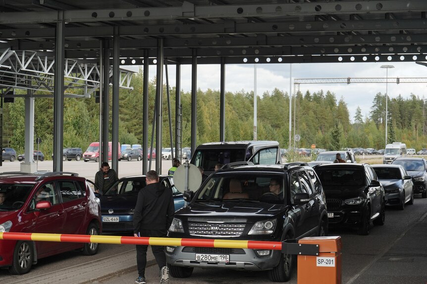 Cars queue at crossing point in Finland and people drive from Russia.