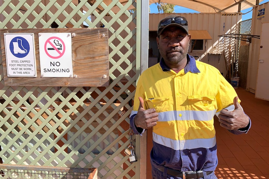 Clayton Hunter is wearing a yellow hi-vis shirt and has two thumbs up.