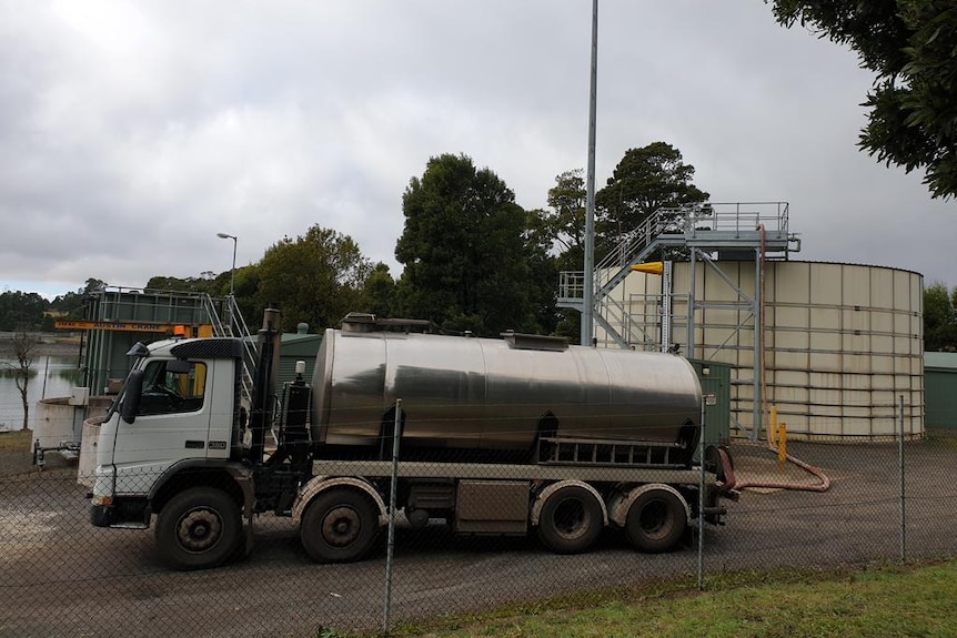 A truck pumps water into the town water tank