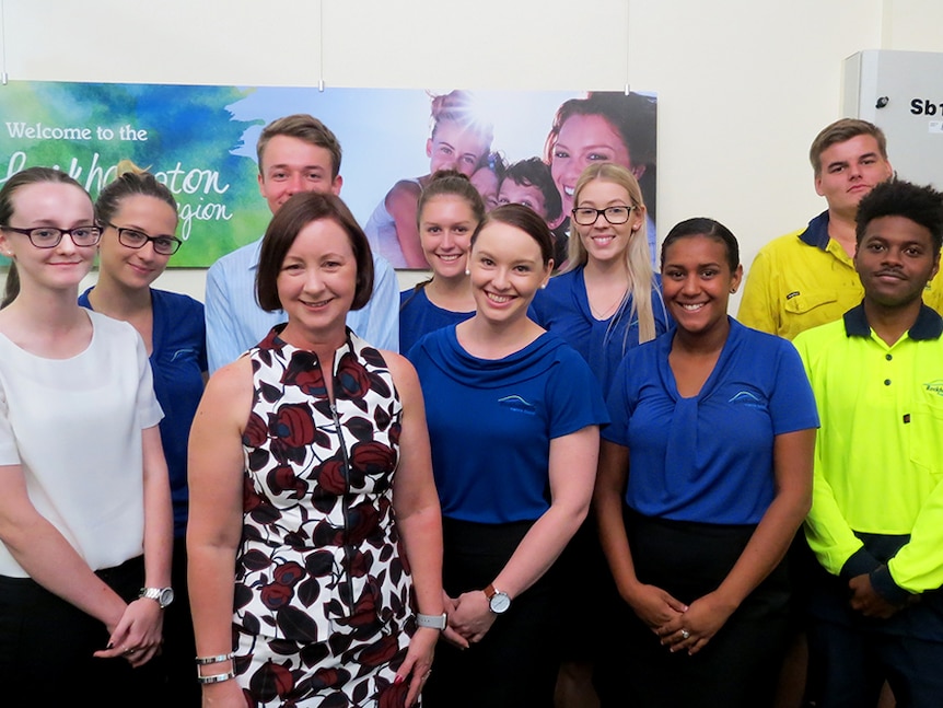 Queensland Attorney General stands in front of group of young people, Rockhampton Council sign in background