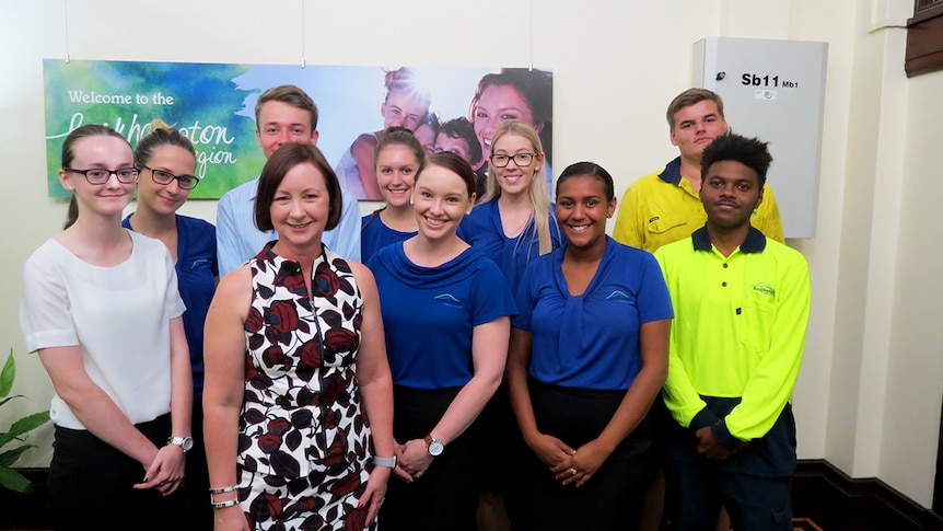 Queensland Attorney General stands in front of group of young people, Rockhampton Council sign in background