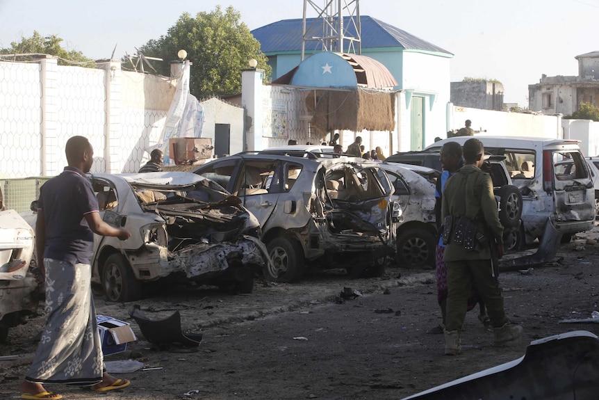 Residents walk past the scene of a bomb attack at Lido beach, Mogadishu