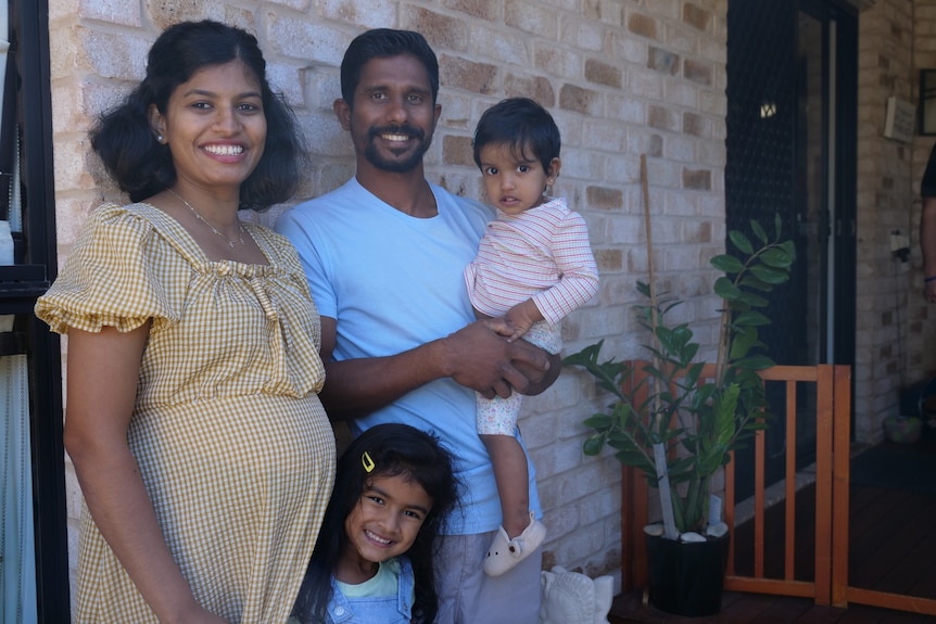 Saivashini, Riswan holding baby Alyaa and Thanushri below, all smiling at the camera.