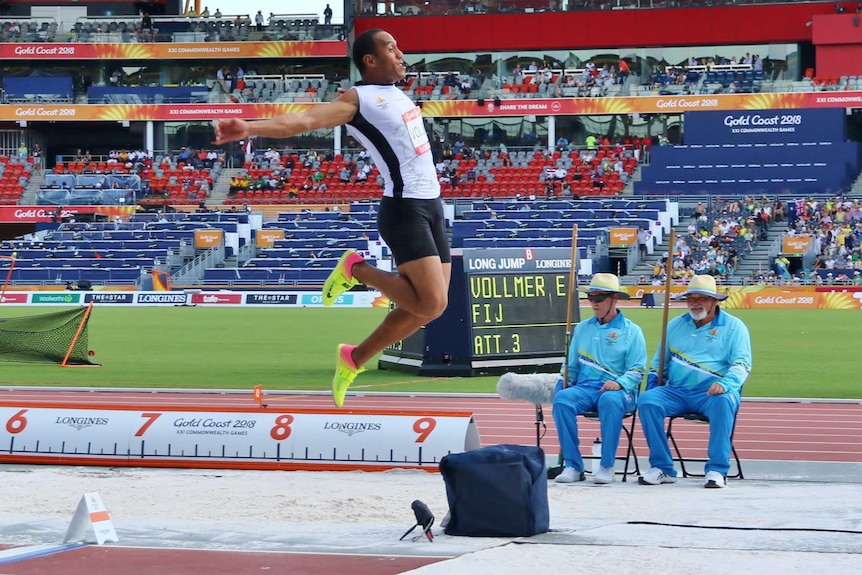 Eugene soars through the air as he completes a jump on the athletics track.