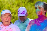 Ken, on the left, and Louis, on the right, wearing white clothes covered in bright colours after doing a colour run