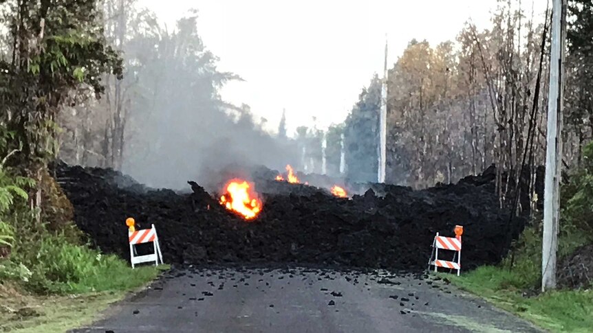 A residential street is blocked by a lava flow from the eruption.