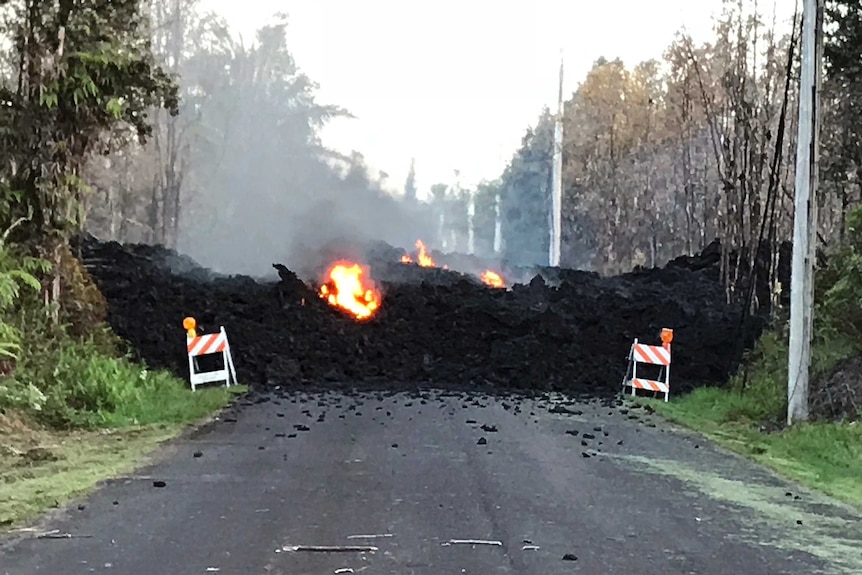 A residential street is blocked by a lava flow from the eruption.