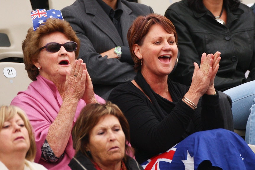 Dellacqua's grandmother and mum clap and cheer in the crowd. Her grandmother wears a mini Australian flag in her hair
