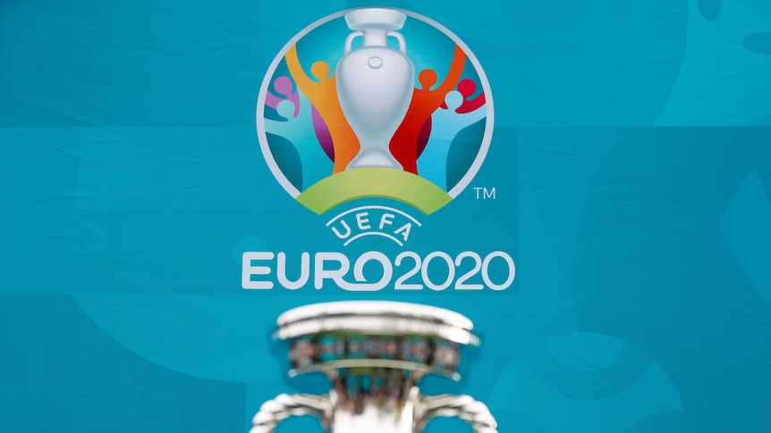 Un logo de l'Euro 2020 est affiché avec le haut d'un trophée d'argent au premier plan