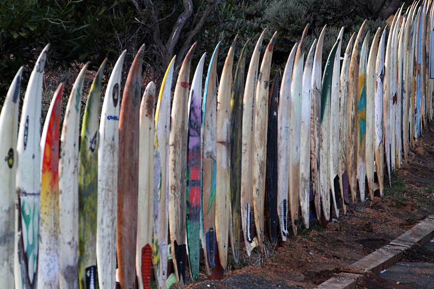 A fence made out of old surfboards