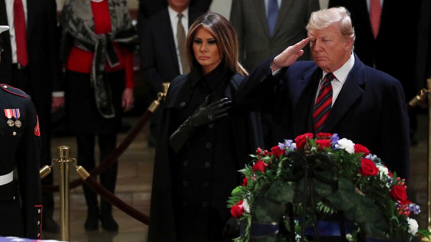 President Trump and Melania Trump salute the coffin of George HW Bush