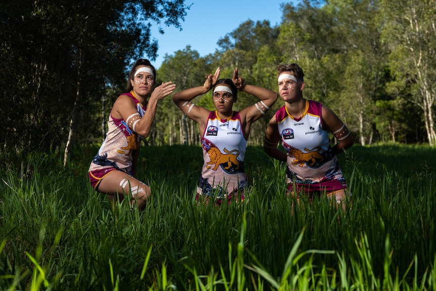 Dakota Davidson, Ally Anderson and Courtney Hodder in colourful guernsey's, long grass, painted up, holding poses.