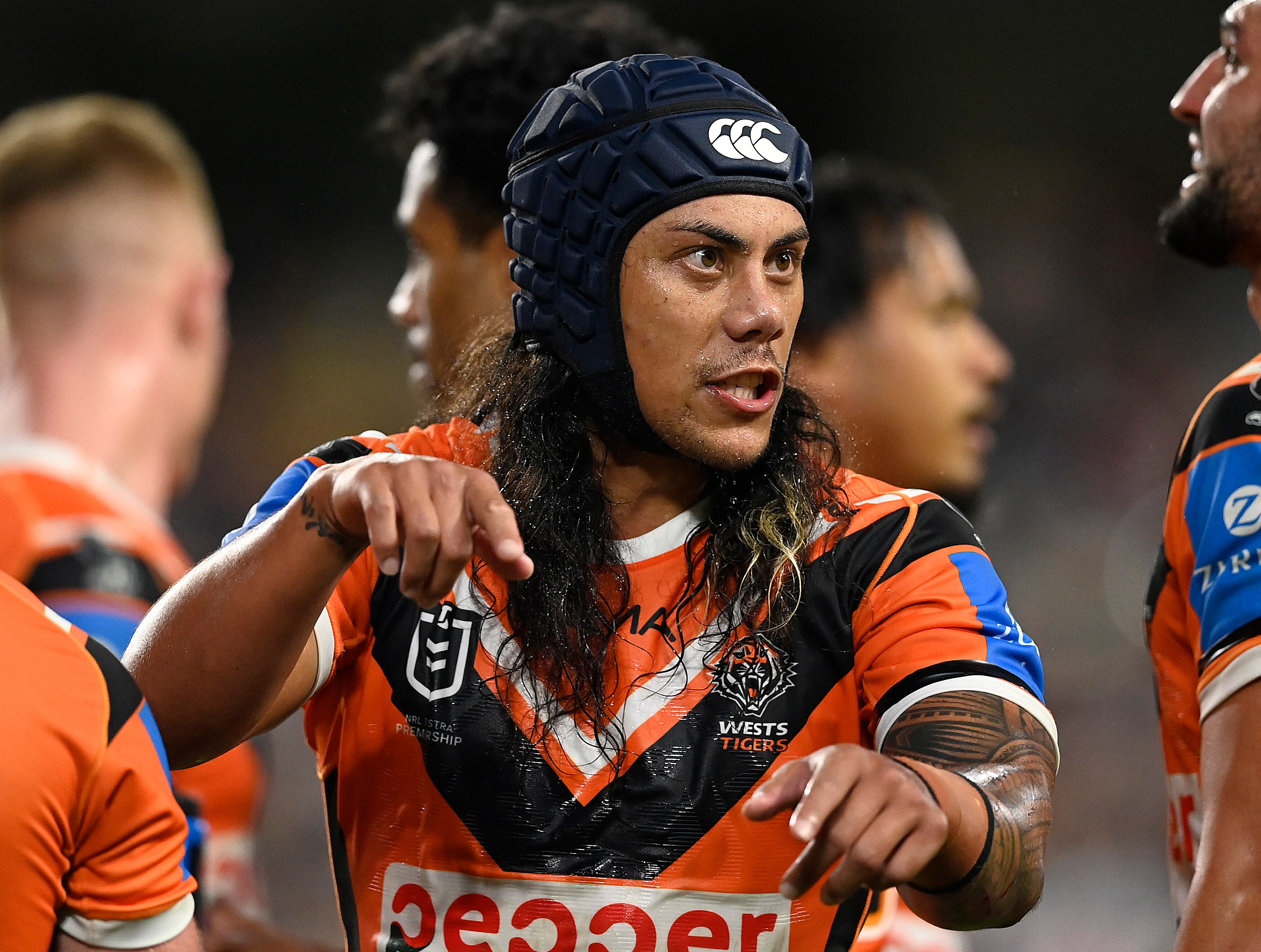 Un hombre le da un gesto a un compañero de equipo durante un partido de la liga de rugby 