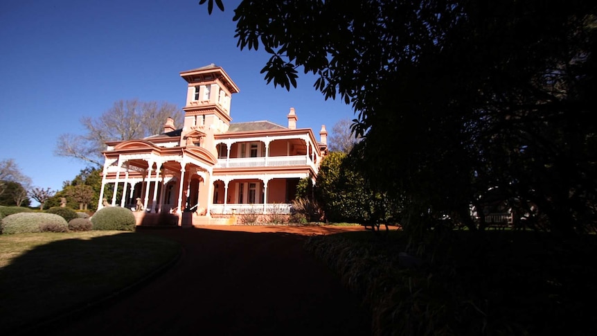 Exterior shot of a large pink mansion