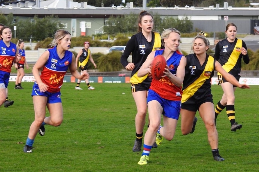 An action shot of women playing football
