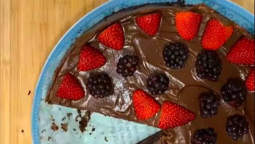 aerial view of chocolat cake with red strawberries and blackberries on top 