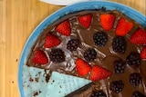 aerial view of chocolat cake with red strawberries and blackberries on top 