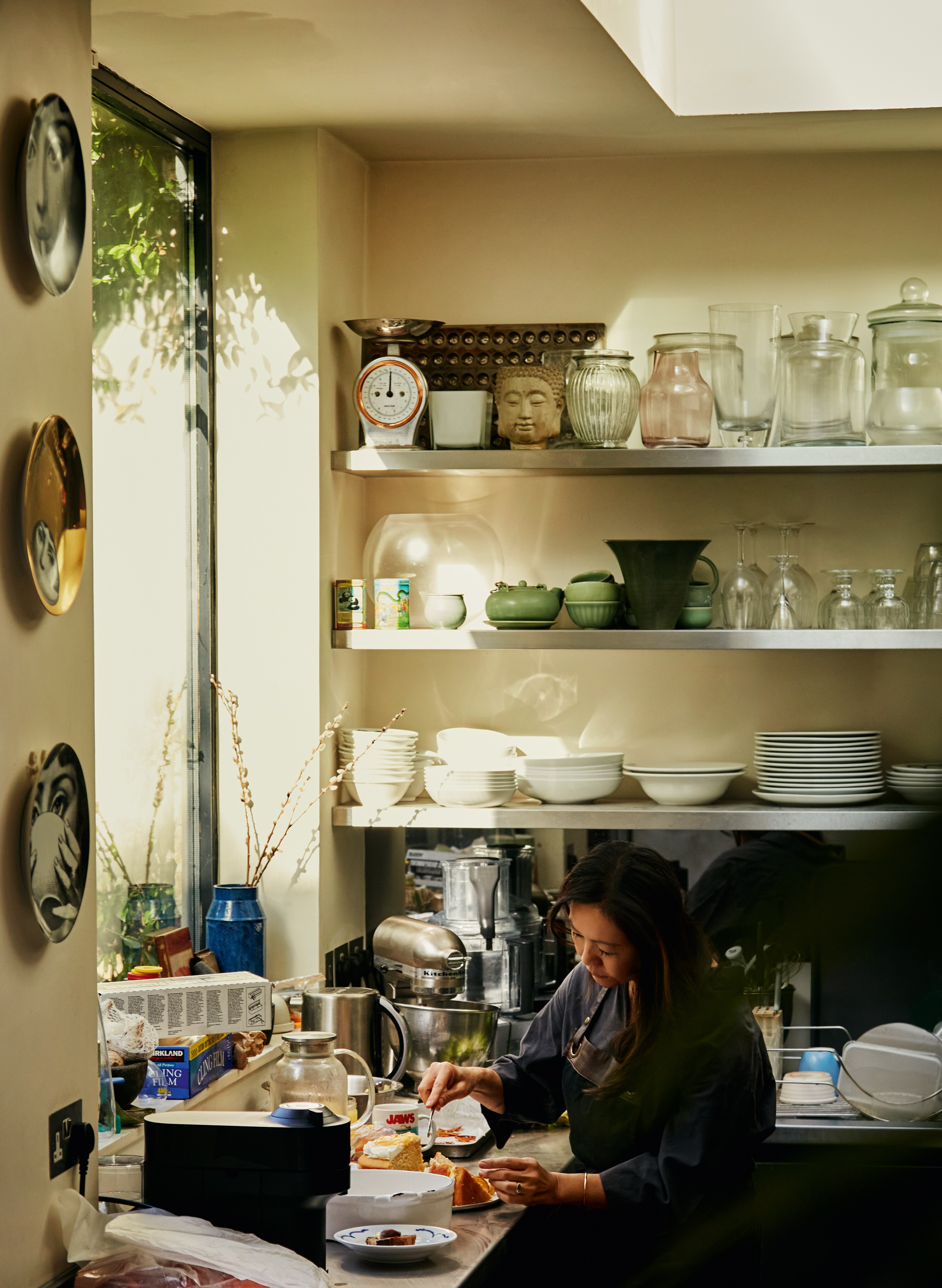 Helen Goh in a well-appointed kitchen inspects a slice of cake.