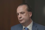 Head shot of Peter V'Landys, CEO of Racing NSW, sitting in an office with blurry brown background