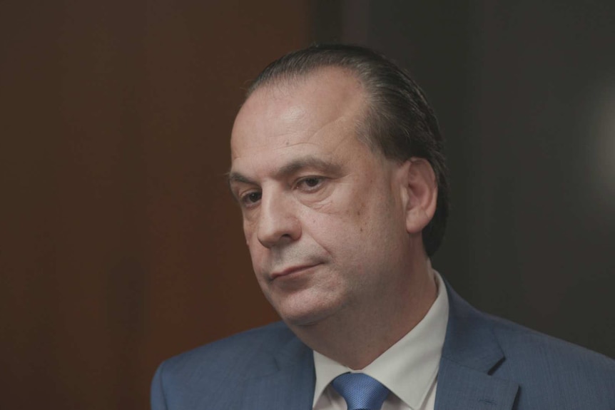 Head shot of Peter V'Landys, CEO of Racing NSW, sitting in an office with blurry brown background