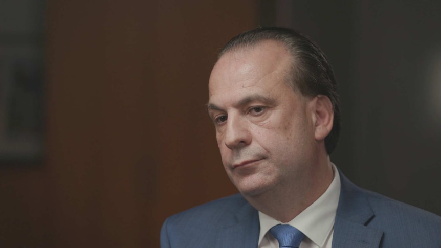 Peter V'Landys, CEO of Racing NSW, sitting in an office with blurry brown background