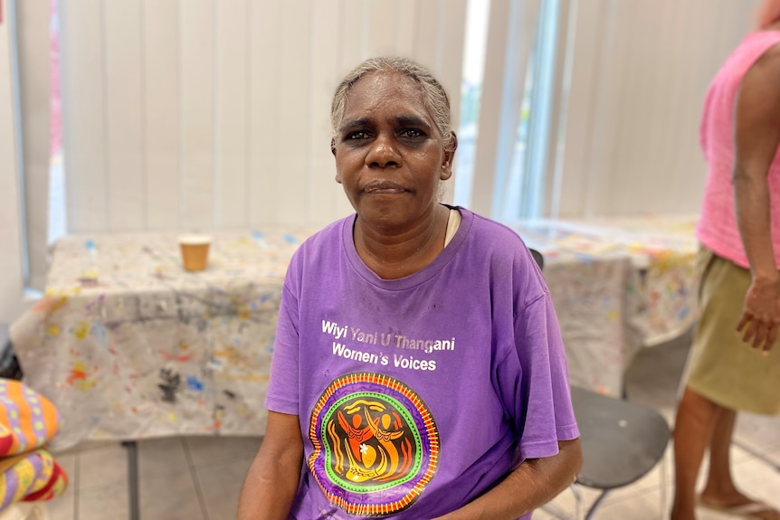 an Aboriginal woman wearing a purple t shirt