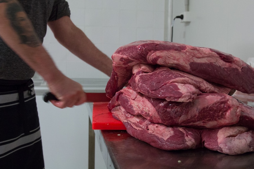 Beef brisket being cut for artisan sausages by butcher Tim Casey, Alexandria, 30 June 2016
