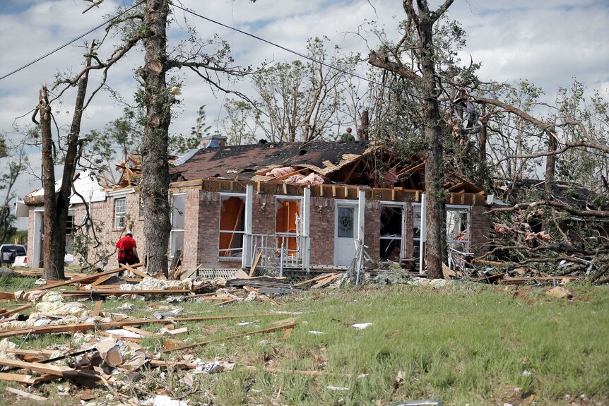 Homeowners clean up debris after a tornado hit the town of Emory, Texas, U.S. April 30, 2017.