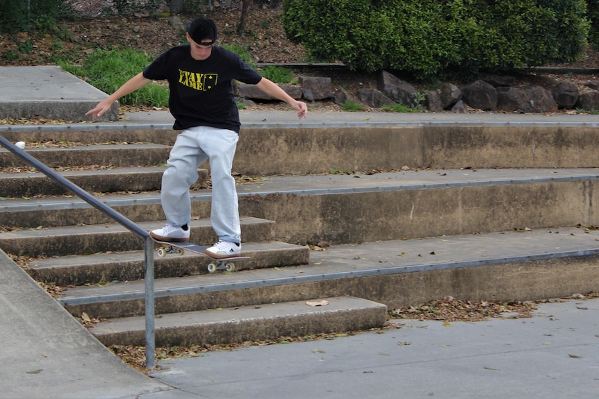 man skateboarding down rail