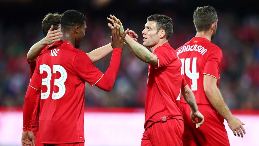 Milner and Ibe celebrate Liverpool's goal against Adelaide United