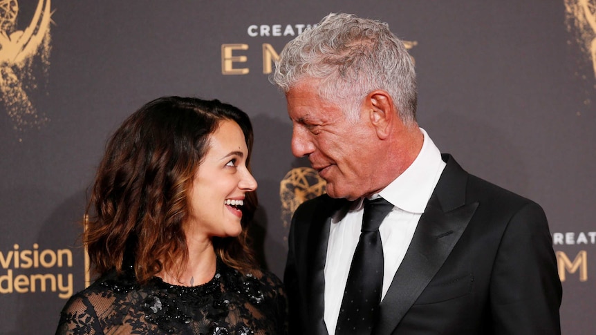 Anthony Bourdain and Asia Argento look at each other and smile