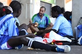 A man coaches a group of young soccer players.