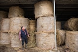 Dairy farmer Michael Perkins with bales of donated hay